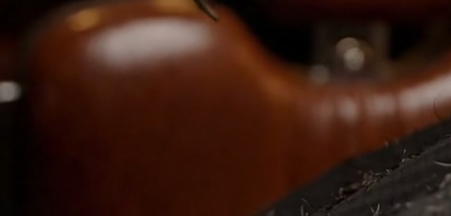 Encosto de uma poltrona de couro marrom, com reflexos de luz