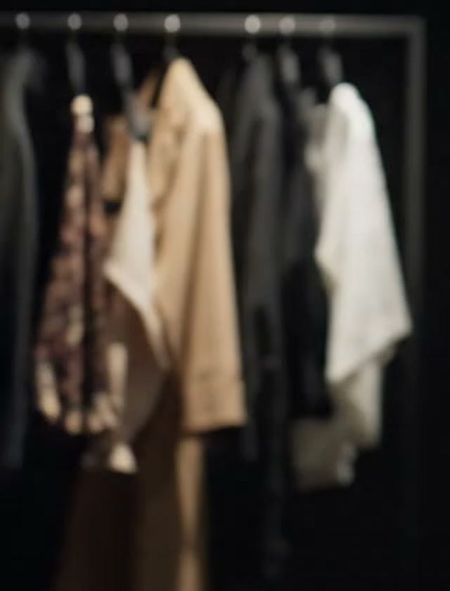 Arara com camisas brancas, uma blusa estampada e peças em tons de areia e preto