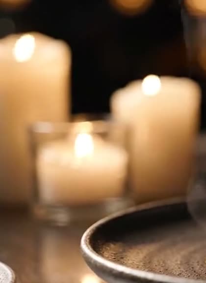 Velas acesas sobre a mesa, com luzes desfocadas ao fundo
